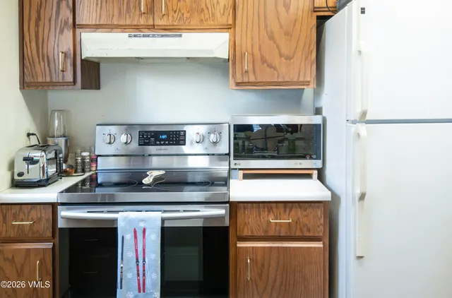a kitchen with stainless steel appliances granite countertop a stove and a refrigerator