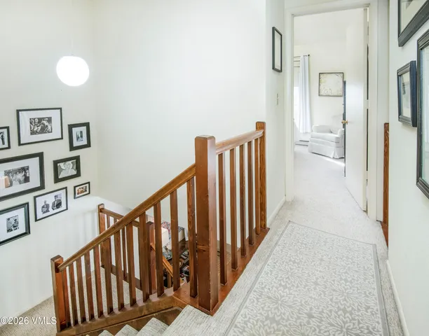 a view of a hallway with wooden floor and stairs