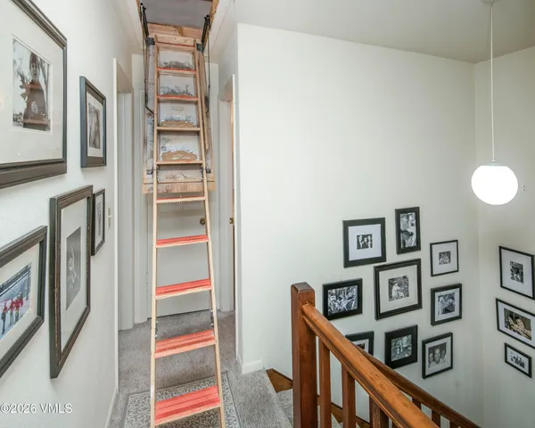 a view of a hallway with furniture and paintings on the wall
