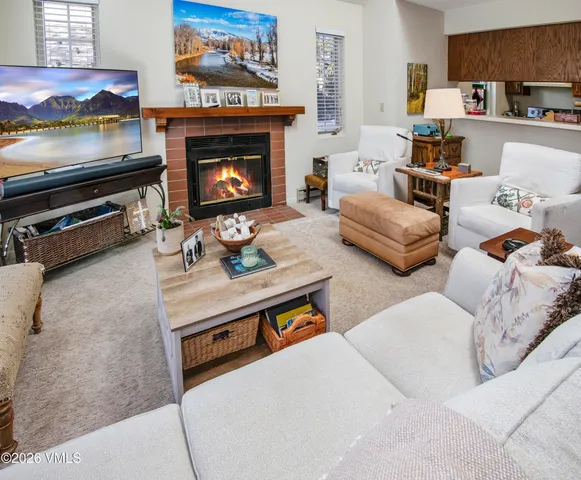 a living room with furniture a flat screen tv and a fireplace