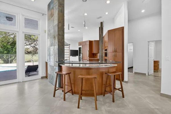 a large kitchen with stainless steel appliances granite countertop a refrigerator and a sink