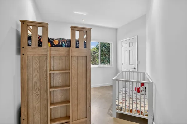 a large bed sitting in a bedroom next to a window