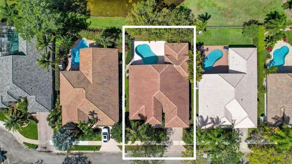 an aerial view of residential houses with outdoor space and lake view in back