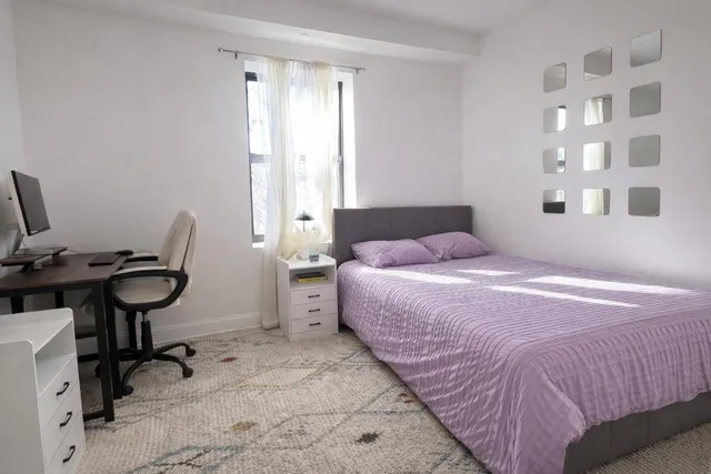 a bedroom with a bed and a desk