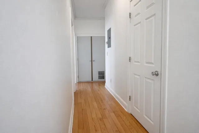 a view of a hallway with wooden floor