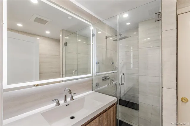 a bathroom with a shower sink and mirror