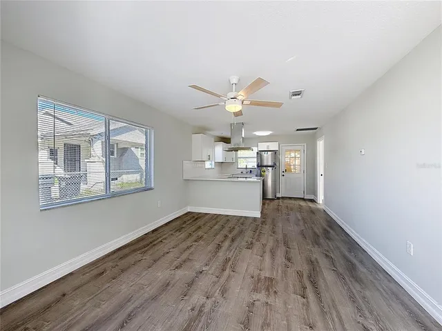 a view of a kitchen with wooden floor and a window