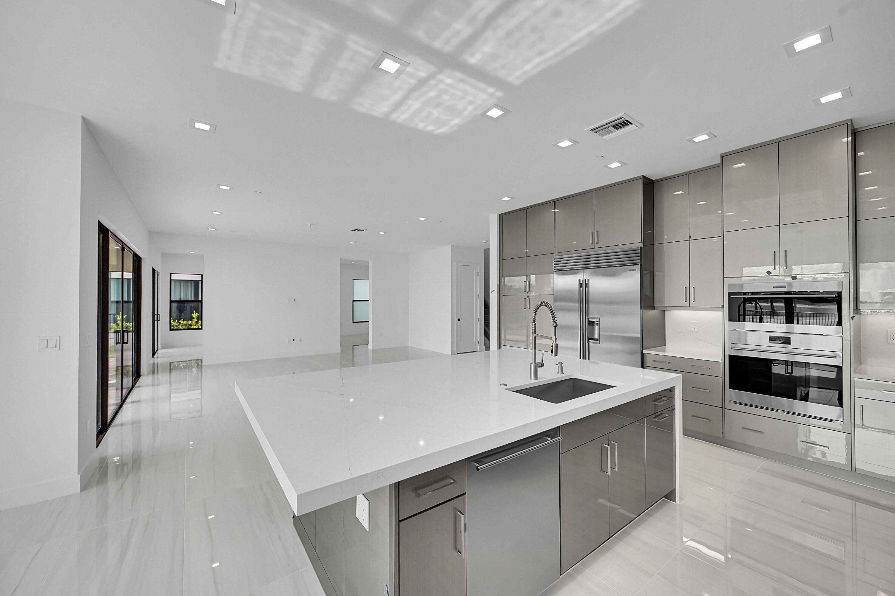 9979 Migration Point Palm Beach Gardens, FL 33412 - Photo 19 of 81 a large kitchen with kitchen island a sink stainless steel appliances and a counter top