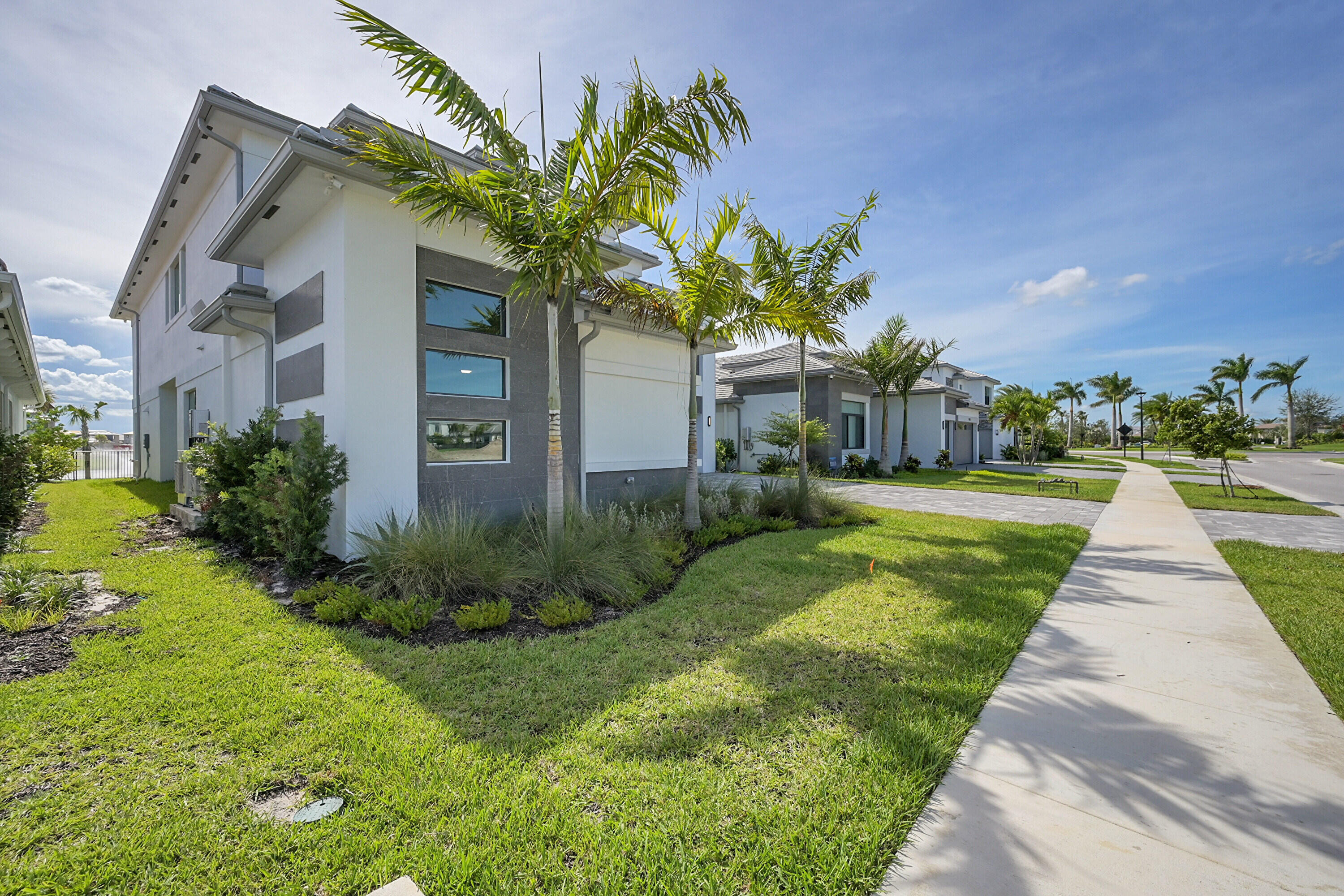 9979 Migration Point Palm Beach Gardens, FL 33412 - Photo 4 of 81 a front view of a house with a yard and potted plants