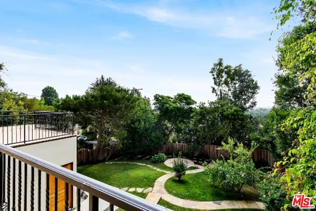 a balcony with wooden fence and trees in the background