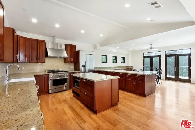 a large kitchen with stainless steel appliances granite countertop a large counter top and a stove