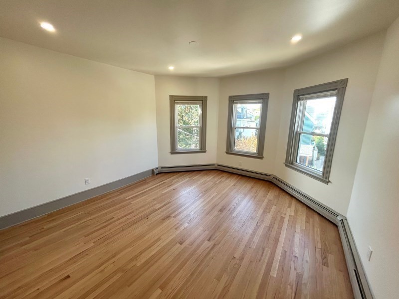 116 Prospect Street, Unit 1 Somerville, MA 02143 - Photo 12 of 21 a view of an empty room with wooden floor and window