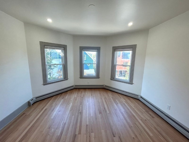 116 Prospect Street, Unit 1 Somerville, MA 02143 - Photo 13 of 21 an empty room with wooden floor and windows