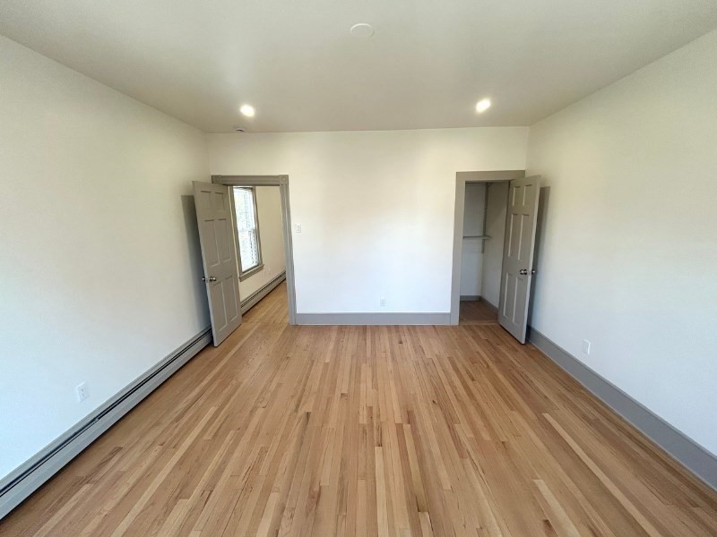 116 Prospect Street, Unit 1 Somerville, MA 02143 - Photo 15 of 21 wooden floor in an empty room with a window