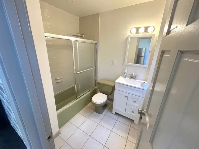 a bathroom with a granite countertop toilet sink and a mirror