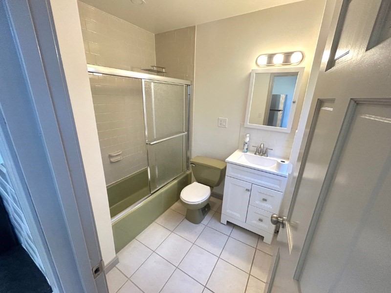 116 Prospect Street, Unit 1 Somerville, MA 02143 - Photo 20 of 21 a bathroom with a granite countertop toilet sink and a mirror