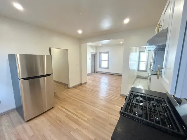 a kitchen with sink a refrigerator and wooden floor