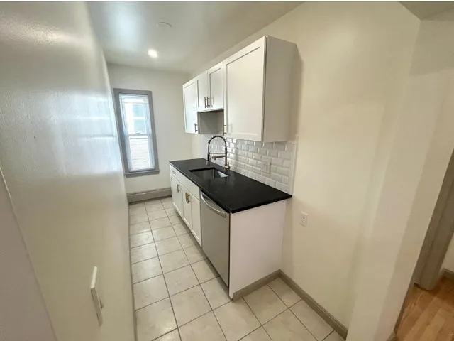 a kitchen with granite countertop a sink and a stove