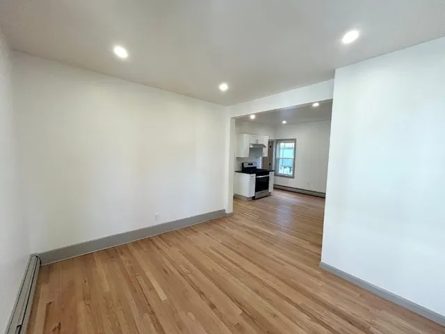a view of empty room with wooden floor