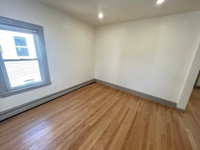 116 Prospect Street, Unit 1 Somerville, MA 02143 - Photo 10 of 21 a view of empty room with wooden floor and fan