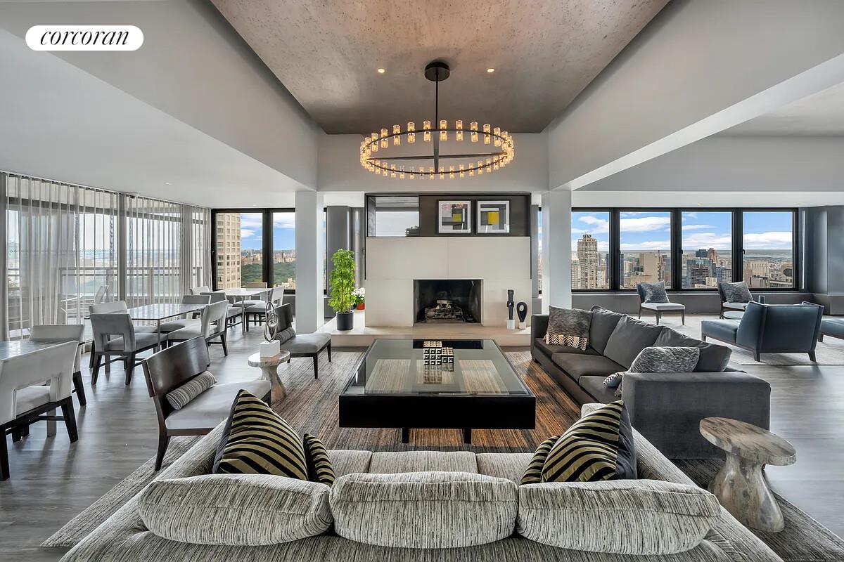 117 East 57th Street, Unit 32G Manhattan, NY 10022 - Photo 9 of 13 a living room with furniture a fireplace and a large window