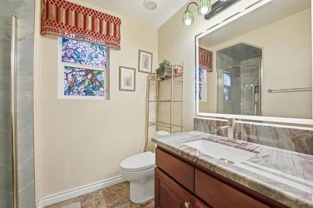 a bathroom with a granite countertop sink and a mirror