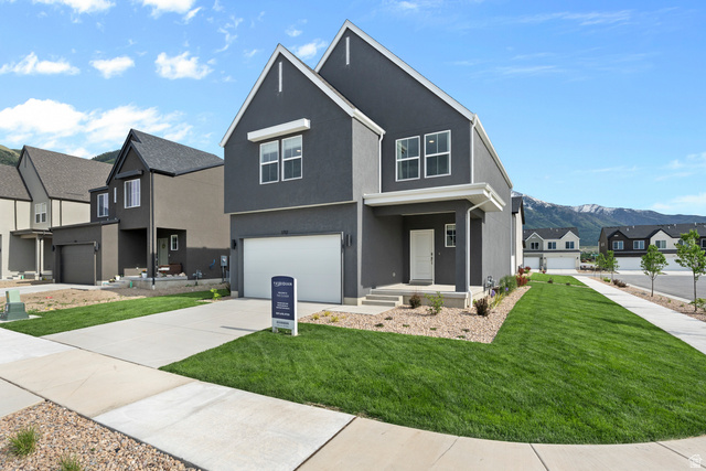 722 West 2840 South, Unit 8 Logan, UT 84321 - Photo 4 of 23 View of front of property with a residential view, a garage, stucco siding, concrete driveway, and a front lawn