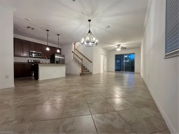 a kitchen with a sink a counter space and chandelier