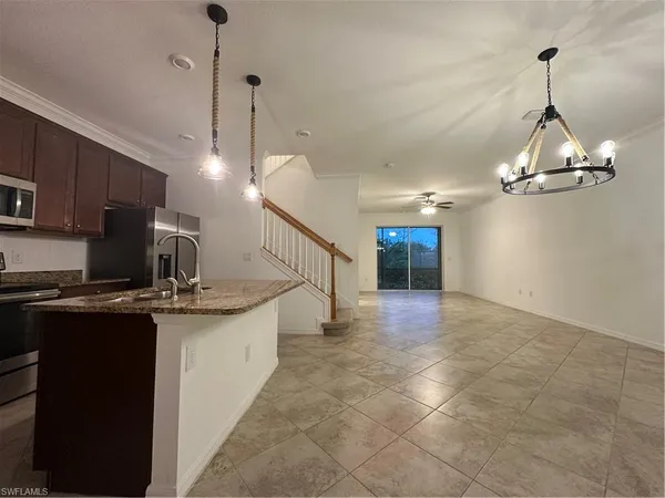 a kitchen with kitchen island granite countertop a sink and stainless steel appliances
