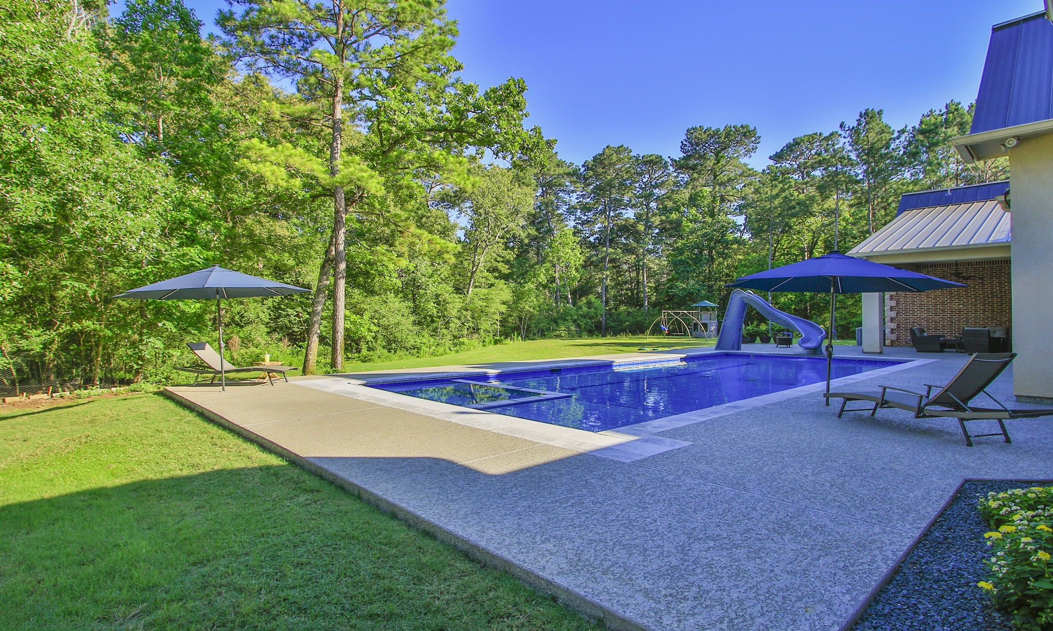 36702 Deer Valley Magnolia, TX 77355 - Photo 39 of 46 a view of a backyard with lawn chairs under an umbrella