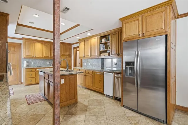 a kitchen with stainless steel appliances granite countertop a stove a sink and a refrigerator