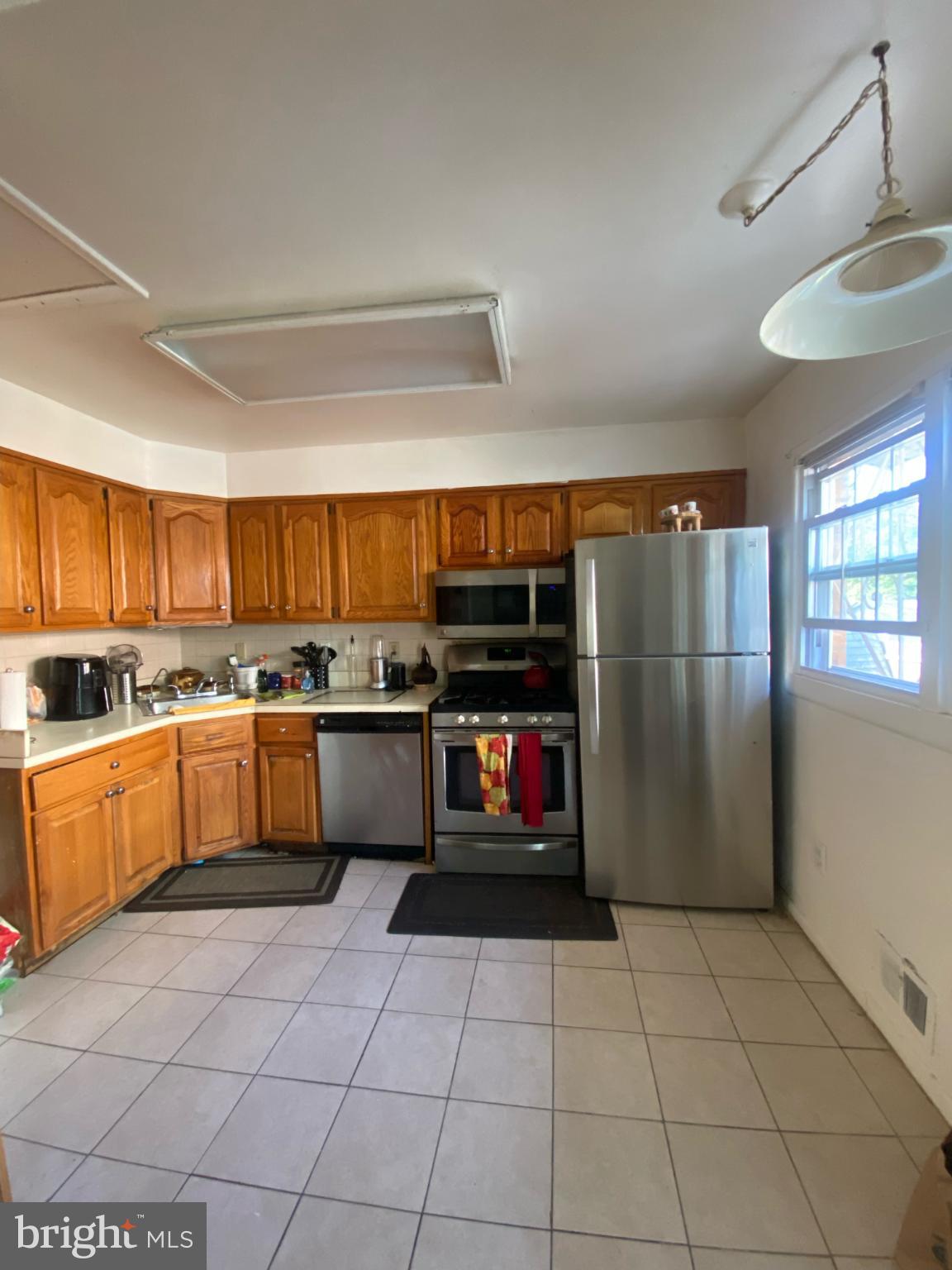 9601 East Light Drive Silver Spring, MD 20903 - Photo 8 of 25 a white kitchen with stainless steel appliances granite countertop a refrigerator and a stove top oven
