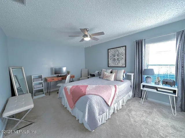 a spacious bedroom with a bed and a chandelier
