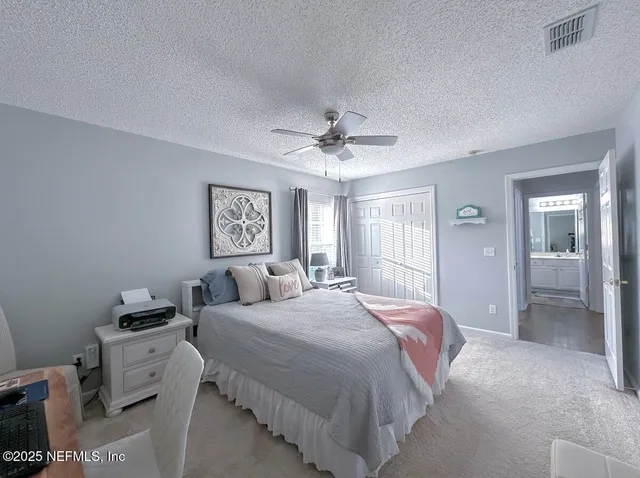 a spacious bedroom with a bed and a flat screen tv