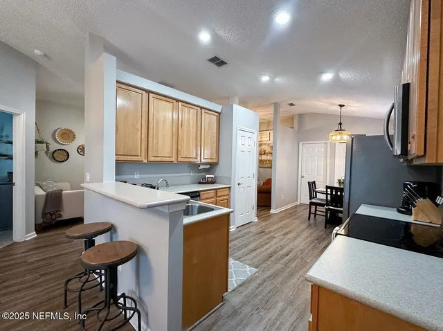 a kitchen with stainless steel appliances granite countertop a stove a sink dishwasher and a microwave oven with white cabinets