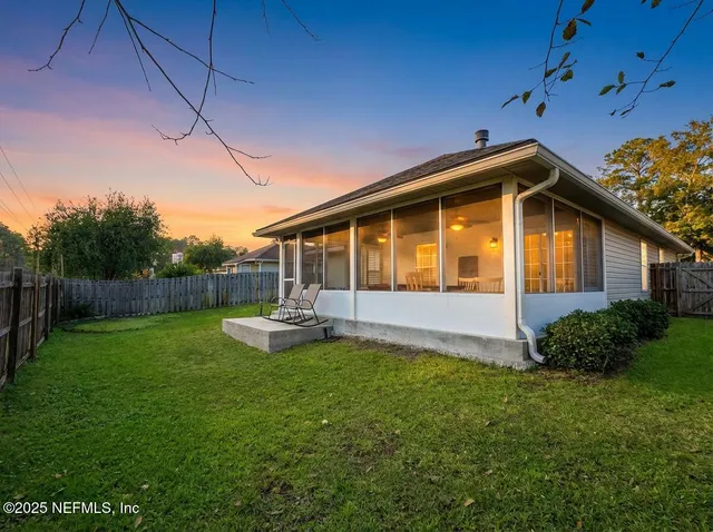 a view of a house with backyard and sitting area