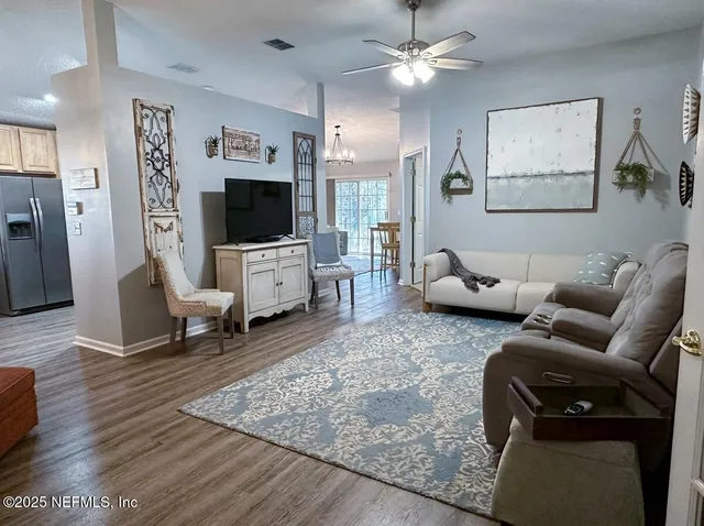 a living room with furniture a flat screen tv and a fireplace