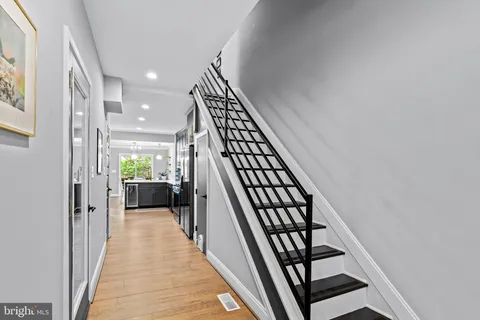 a view of a hallway with wooden floor and staircase
