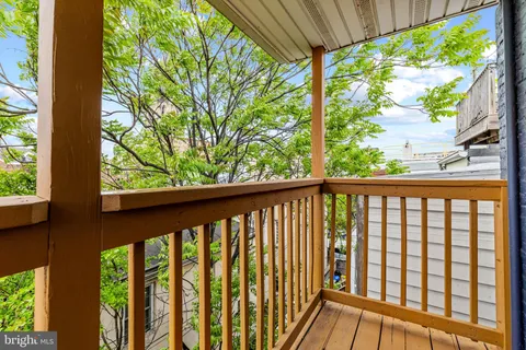 a view of a balcony with a dining table and chairs with wooden floor