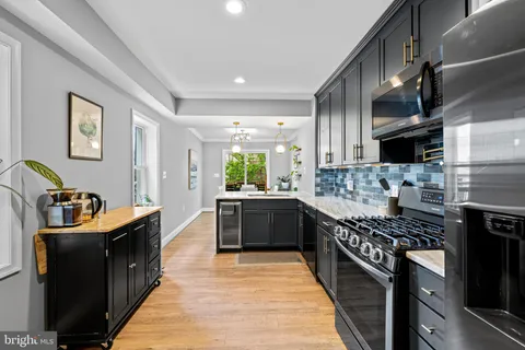 a kitchen with stainless steel appliances kitchen island granite countertop a stove a sink dishwasher and a refrigerator