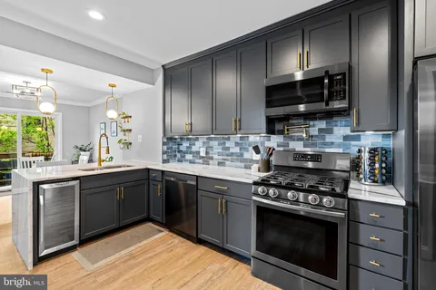 a kitchen with stainless steel appliances a stove sink and cabinets