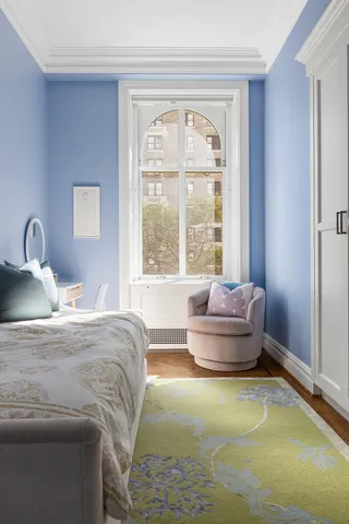 a bedroom with a bed and a large window