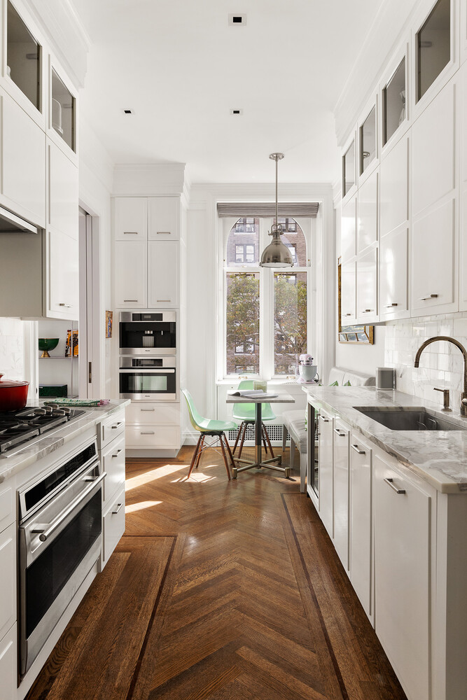 390 West End Avenue, Unit 3L Manhattan, NY 10024 - Photo 7 of 18 a kitchen with stainless steel appliances granite countertop a stove top oven a sink a dining table and chairs with wooden floor