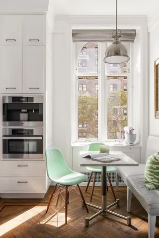 a kitchen with stainless steel appliances granite countertop a stove top oven a sink a dining table and chairs with wooden floor