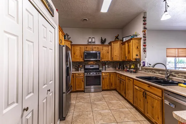 a large kitchen with stainless steel appliances granite countertop a stove and a sink