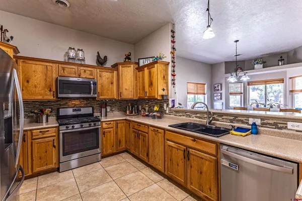 a kitchen with stainless steel appliances a stove sink microwave and cabinets
