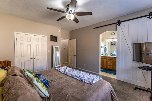 a bedroom with a bed and a flat tv screen on a dresser