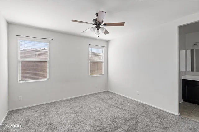 an empty room with fan and windows