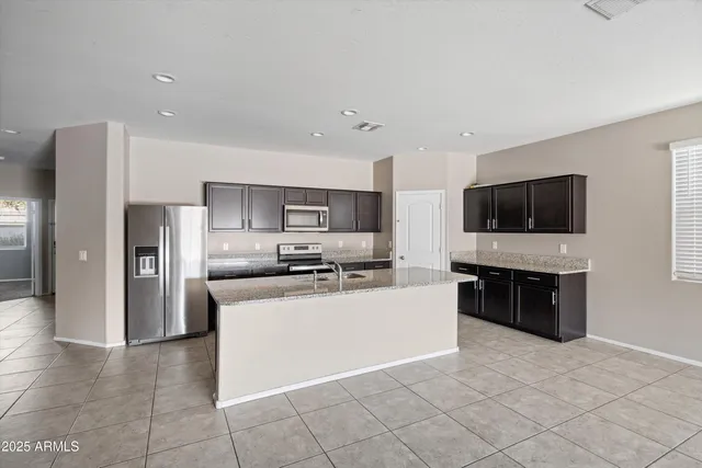 a kitchen with stainless steel appliances a refrigerator and a stove top oven