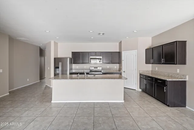 a large kitchen with a stove top oven and stainless steel appliances